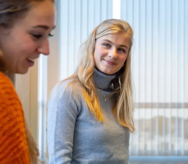 Vrouw kijkt naar andere vrouw lachend