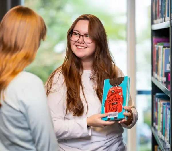 student haalt boek van de boekenplank