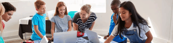 Leerlingen die samen met de lerares een ICT project uitvoeren.