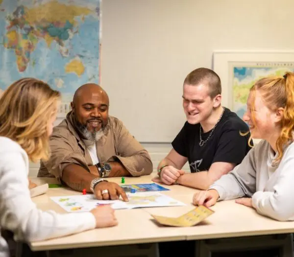 docent helpt studenten aan tafel