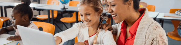 Een lerares en leerling die samen kijken naar een laptopscherm.