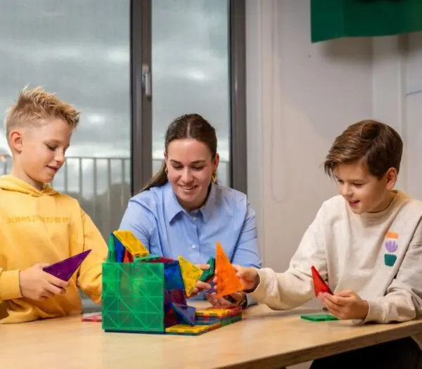 Pabo student speelt een spel met twee leerlingen