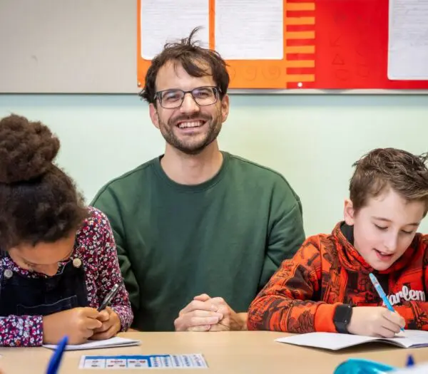 Docent zit tussen twee leerlingen in