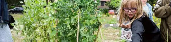 Meisje staat tussen de planten