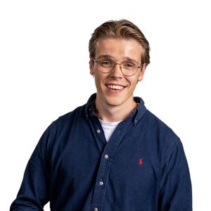 jongen kijkt lachend in de camera