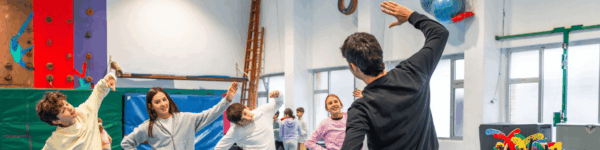 Vier leerlingen op een rij die sporten met een gymdocent.