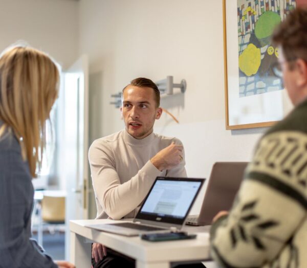 Drie studenten werken met elkaar
