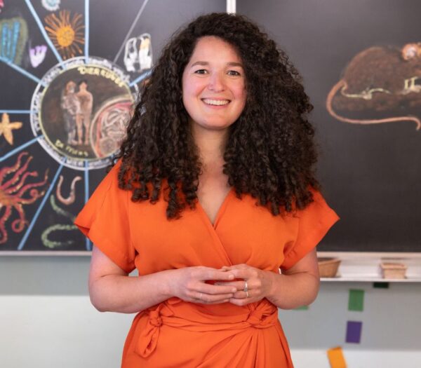 vrouw kijkt lachend de camera in