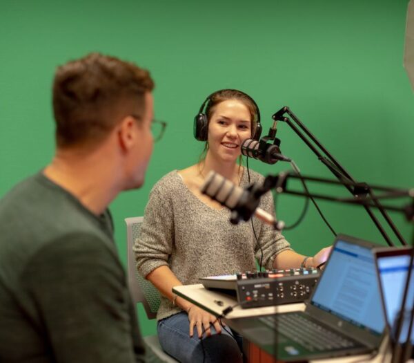 Twee mensen in een podcaststudio