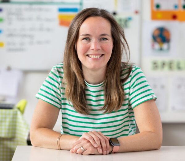 Vrouw kijkt lachend de camera in