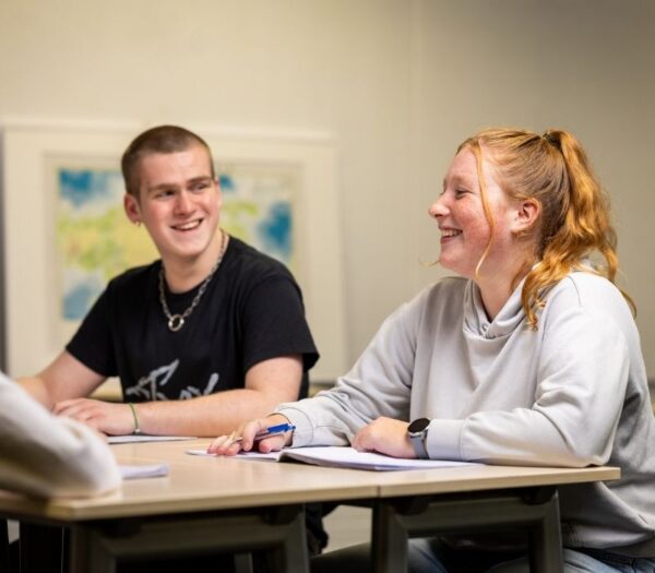 twee studenten zitten naast elkaar in de klas