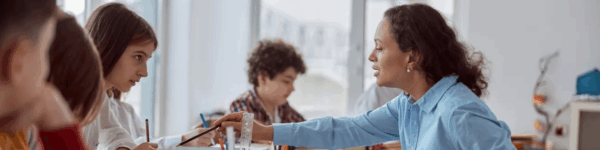 Leerkracht geeft instructies aan leerlingen.