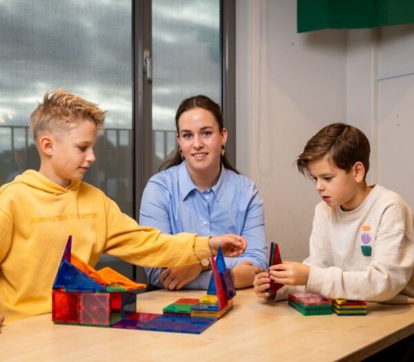 pabo student speelt een spel met twee leerlingen