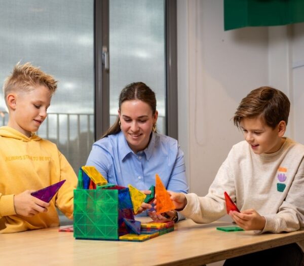 Pabo student speelt een spel met twee leerlingen