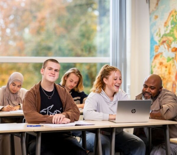 Student in klaslokaal kijkt camera in