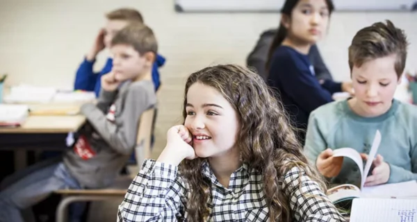 Kinderen op school die aandachtig luisteren.