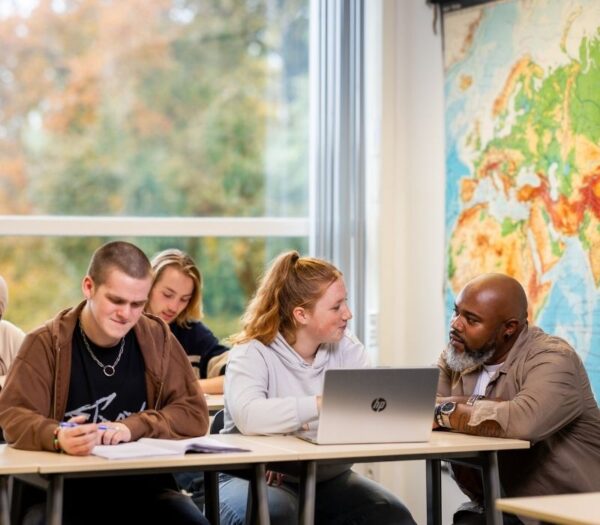 studenten in klaslokaal, een wordt geholpen door docent