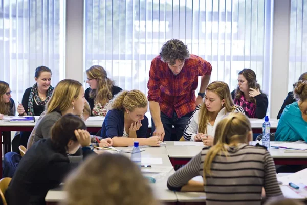 Een klas voor leerlingen waar een docent iets aan uitlegt.
