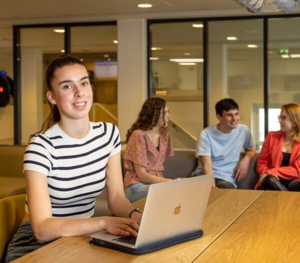 Vrouw zit achter laptop