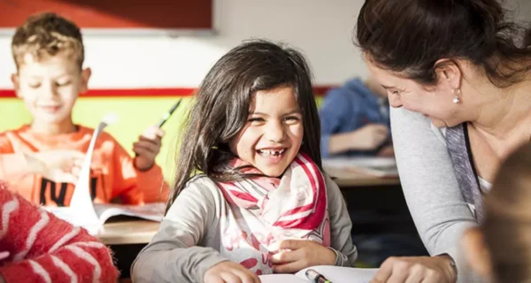 Meisje en lerares die samen lachen.